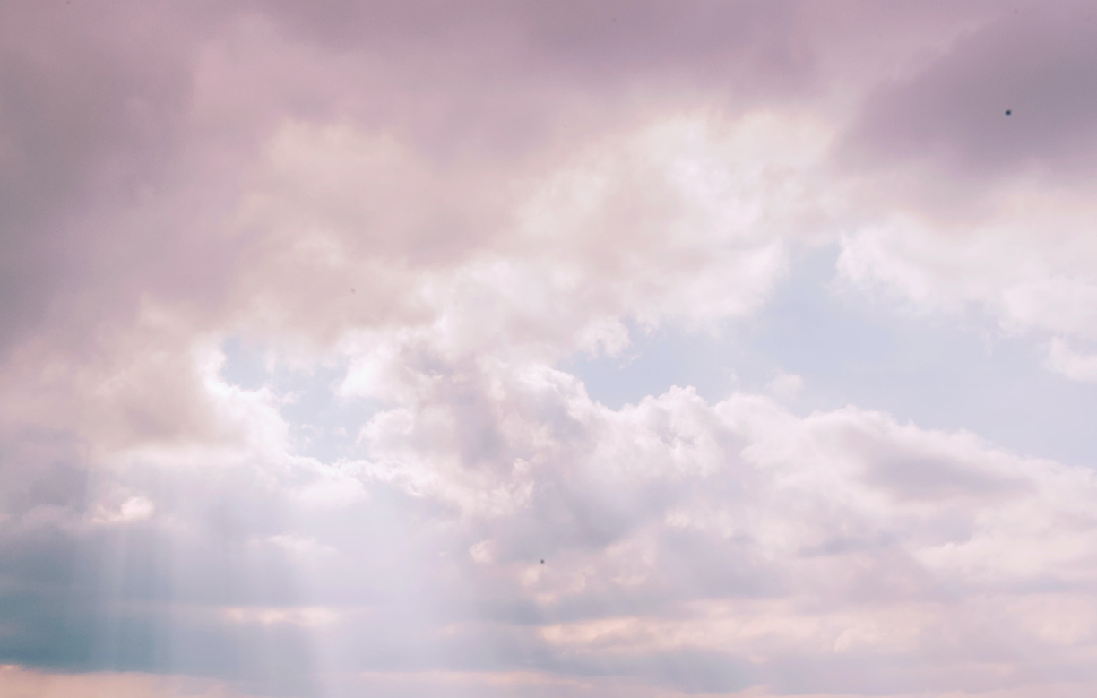 Pink-hued clouds in the sky as sun peeks through.