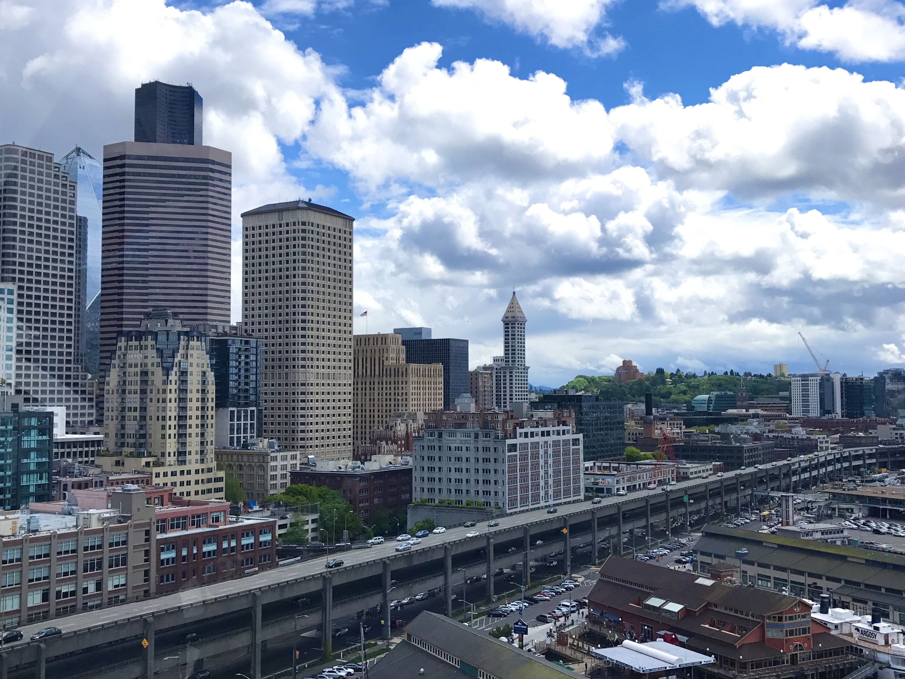 Cityscape with skyscrapers and a cloudy sky.