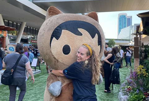 Rebecca Gray hugs one of Salesforce's mascot, Astro.
