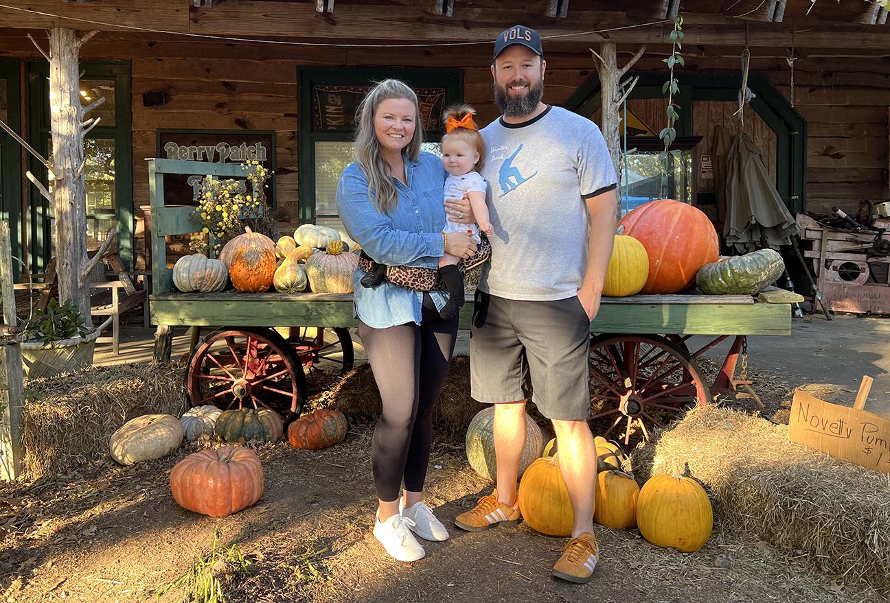 Jessica Toon poses with her husband and daughter at a pumpkin patch.