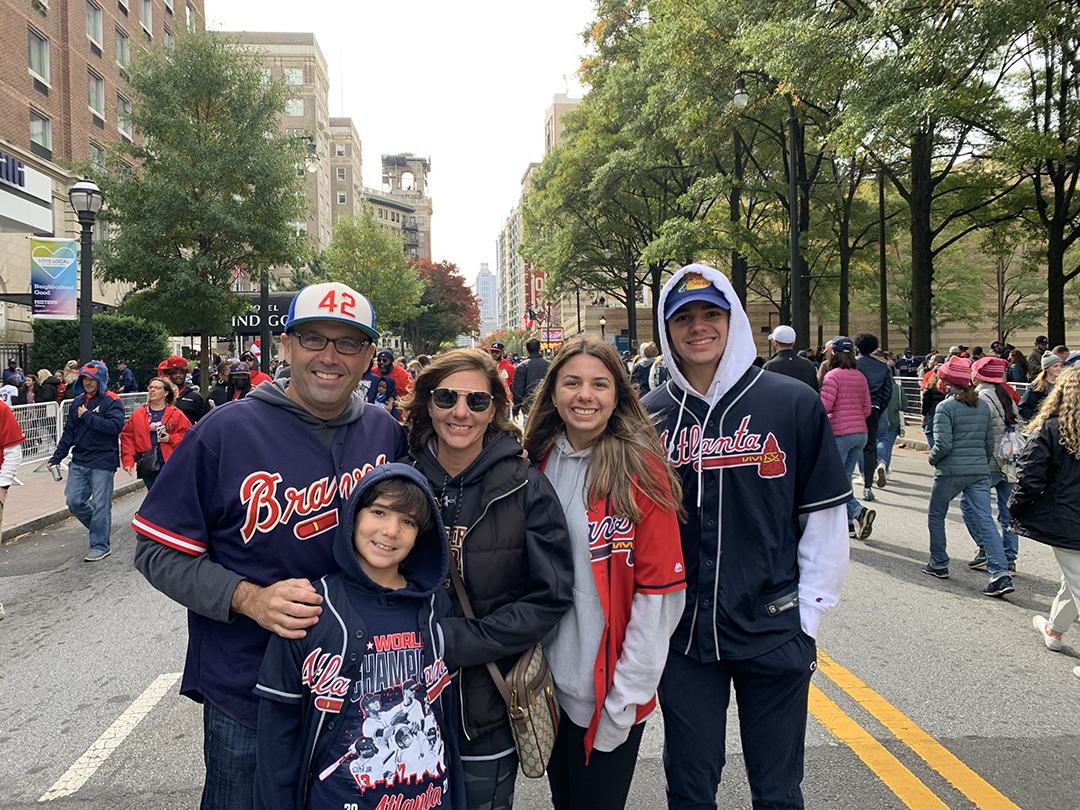Ted Pappas and his family pose at Truist Park while wearing Braves outfits.