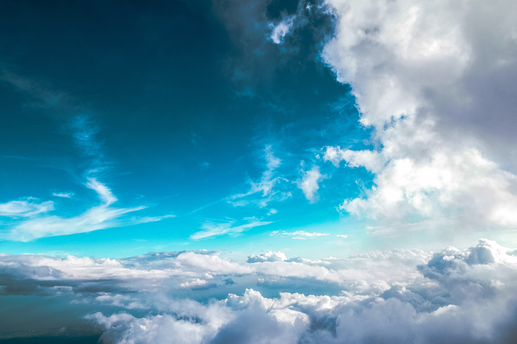 White and gray clouds with a deep-blue and aqua tinted sky.